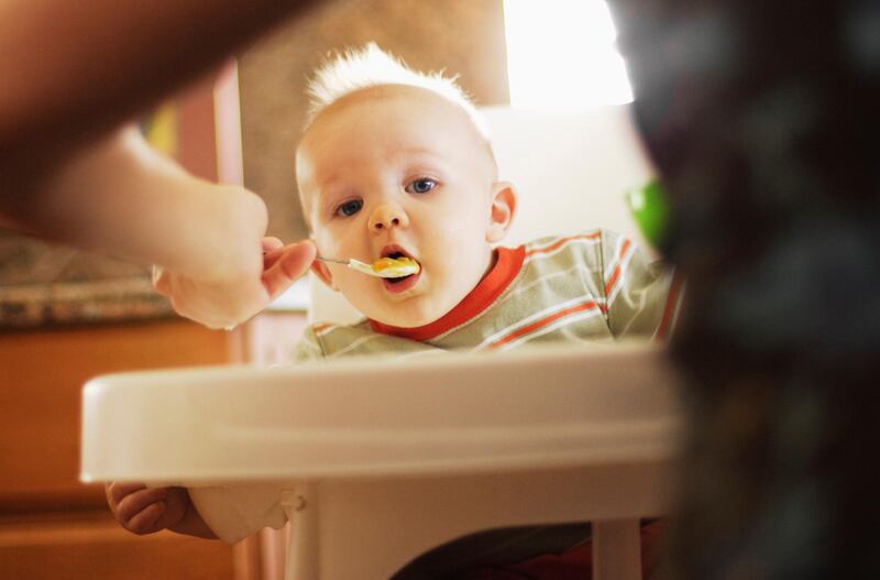 Baby Getting Feed --- Image by © David P. Hall/Corbis