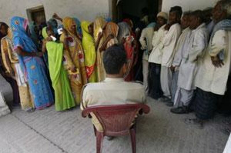 Voters stand in a queue to cast their votes outside a booth at a polling station in Rohania, in the northern Indian state of Uttar Pradesh.