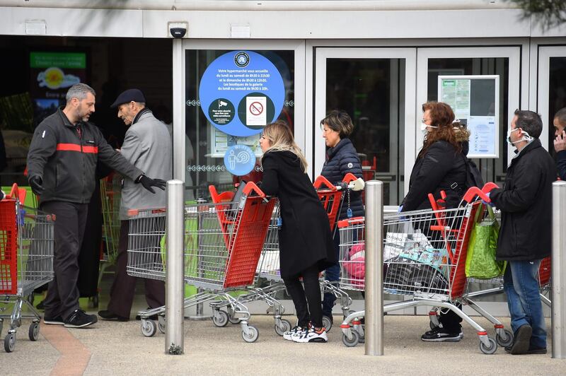 People wait to enter a supermarket, as only 100 people are allowed in at the same time in Montpellier, southern France. Sylvain Thomas / AFP