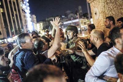 People react towards a Turkish solder at Taksim square in Istanbul on July 16, 2016. 
Turkish military forces on July 16 opened fire on crowds gathered in Istanbul following a coup attempt, causing casualties, an AFP photographer said. The soldiers opened fire on grounds around the first bridge across the Bosphorus dividing Europe and Asia, said the photographer, who saw wounded people being taken to ambulances.

 / AFP PHOTO / HALIT ONUR SANDAL