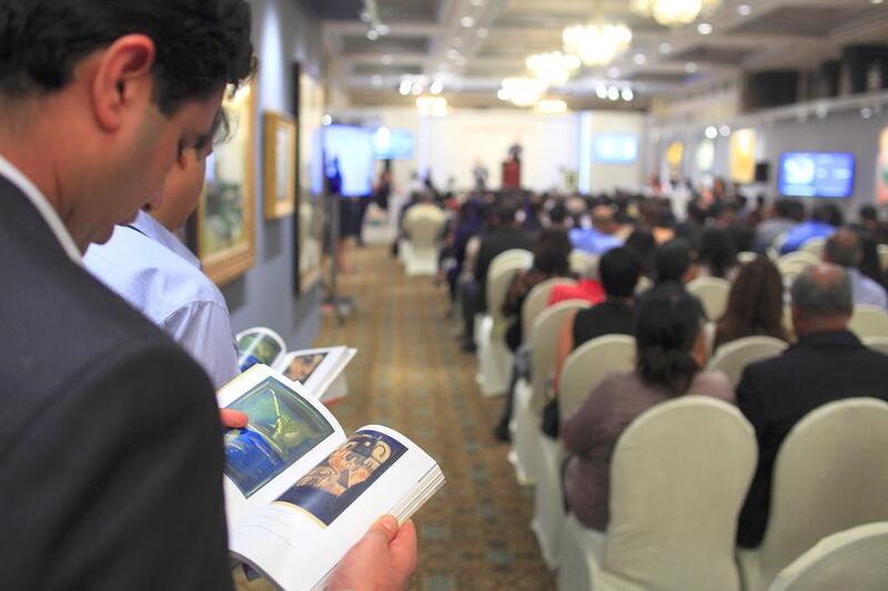 A patron checks the catalogue of Indian art for auction by Christie’s in Mumbai. Subhash Sharma for The National