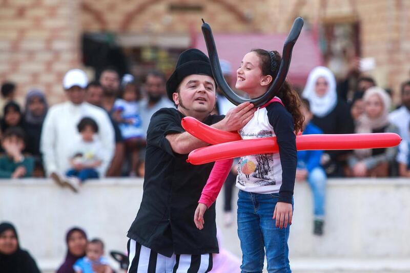 Dolphin creative artist Otto Bas Sotto from Italy does some balloon tricks with the help of a volunteer from the audience. Victor Besa for The National