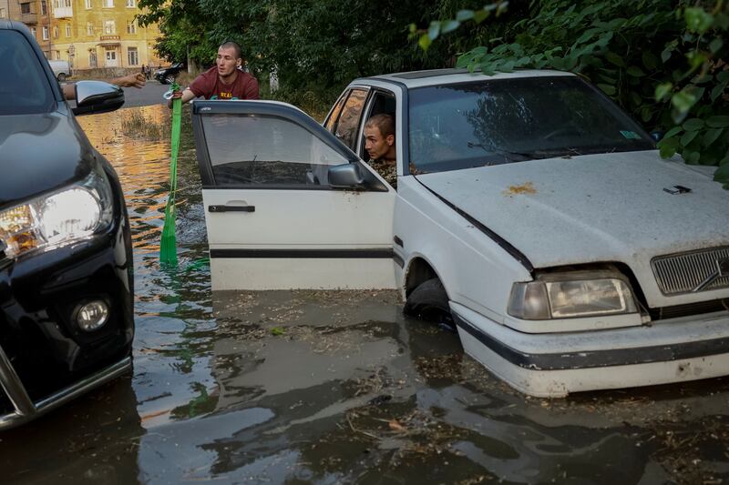 Residents try to retrieve their car from a flooded street in Kherson. Reuters