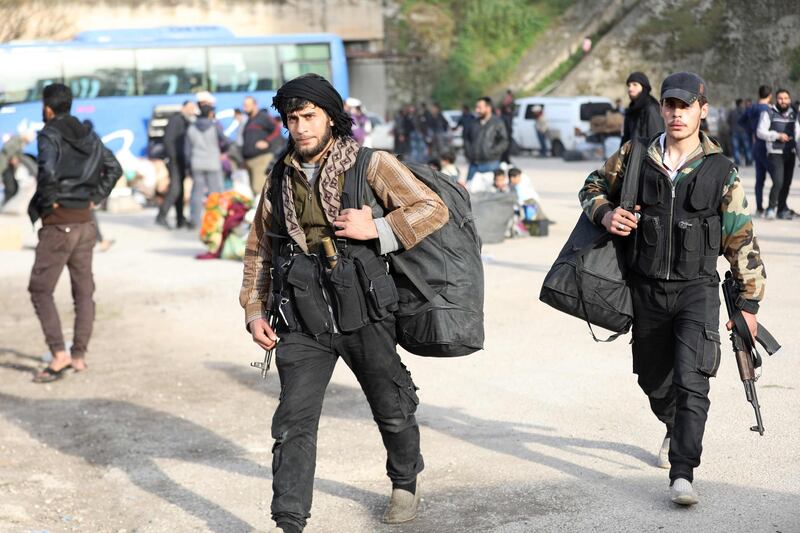Rebel fighters are seen upon their arrival in the Qalaat al-Madiq village in the province of Hama, on March 13, 2018, after being evacuated from the Qadam neighbourhood on the outskirts of Damascus under a deal agreed between the government and opposition fighters. 
With Syria's war set to enter its eighth year this week, fighting continues on several fronts, including around Afrin and in Eastern Ghouta near Damascus, where dozens of civilians including people with medical conditions were evacuated. / AFP PHOTO / OMAR HAJ KADOUR