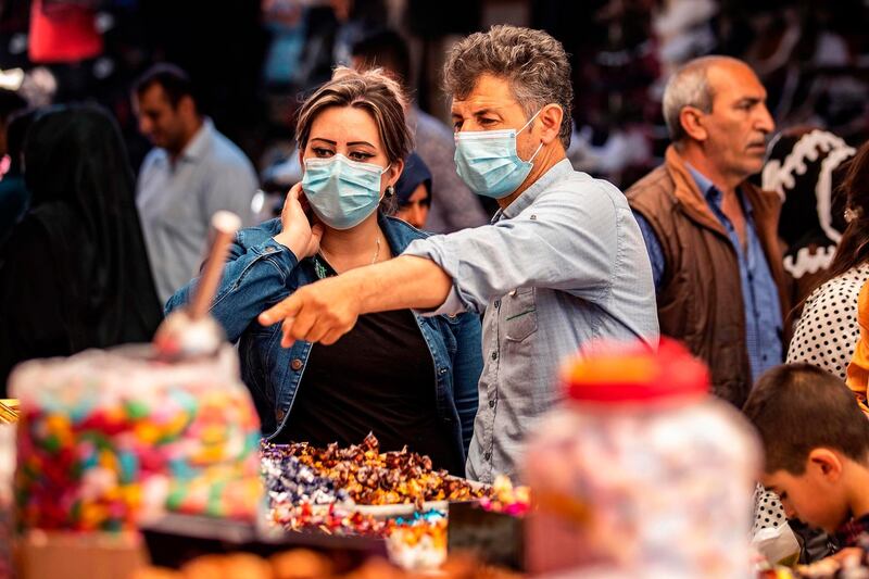 Mask-clad shoppers buy sweets in Syria's north-east Hasakeh province. AFP