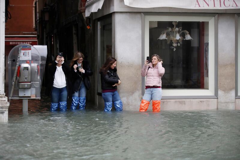 Tourists take pictures of a flooded Venice, Italy. AP Photo