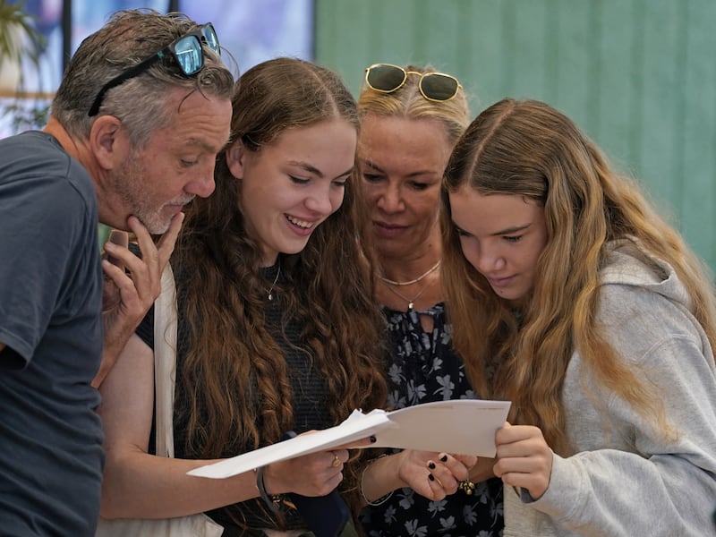 Lili Connell, second left, opens her A-level results with her parents at Brighton Girls school in Brighton, on England's south coast. PA