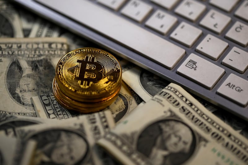 Bitcoin (virtual currency) coins placed on Dollar banknotes, next to computer keyboard, are seen in this illustration picture, November 6, 2017. REUTERS/Dado Ruvic/Illustration