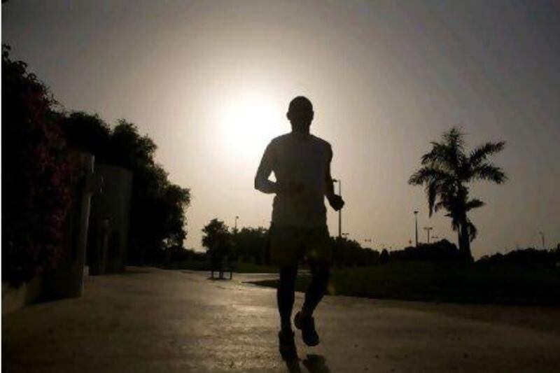 A jogger at Al Safa park, runs in the mid-day heat.