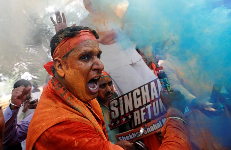 BJP supporters celebrate after learning the initial election results outside the party headquarters in New Delhi. REUTERS