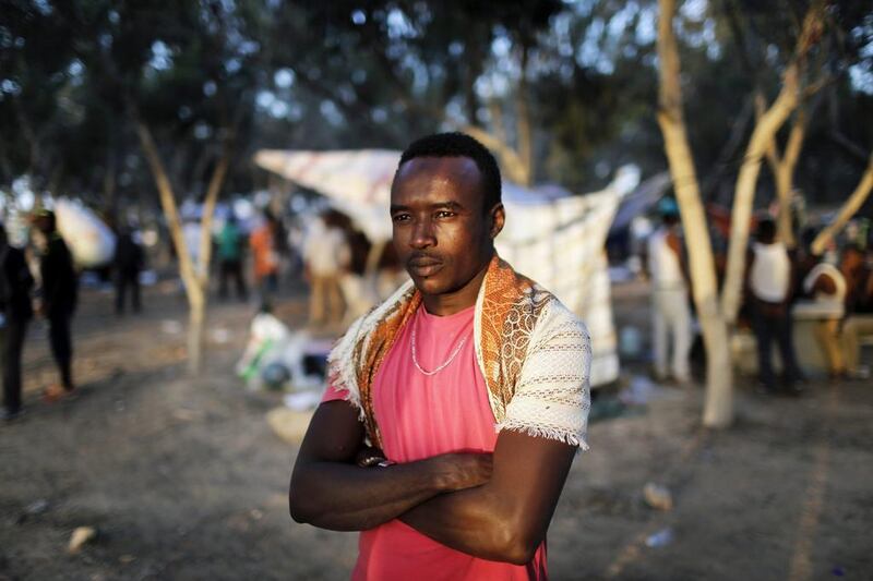 An African asylum seeker stands in the shade of trees during a protest after leaving Holot open detention centre in southern Israel’s Negev desert on June 28, 2014. Finbarr O’Reilly/Reuters