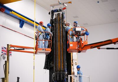 Members of staff work on a satellite at the Airbus factory in Stevenage, England. PA