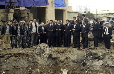 (FILES) In this file photo taken on February 19, 2005, three of the sons of slain Lebanese prime minister Rafiq Hariri Ayman, Saadeddin, and Bahaa (C) pray at the site of a massive explosion in which their father was killed along with 14 people in central Beirut. On Valentine's Day 2005, the former prime minister Rafic Hariri who embodied the reconstruction of the country after its 1975-1990 civil war was killed in a monster bomb attack on his convoy. The special tribunal trying the four suspects accused of the 2005 assassination is expected to deliver its verdict on on August 18, 2020. / AFP / -
