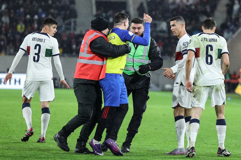 A fan invades the pitch to greet Cristiano Ronaldo. EPA