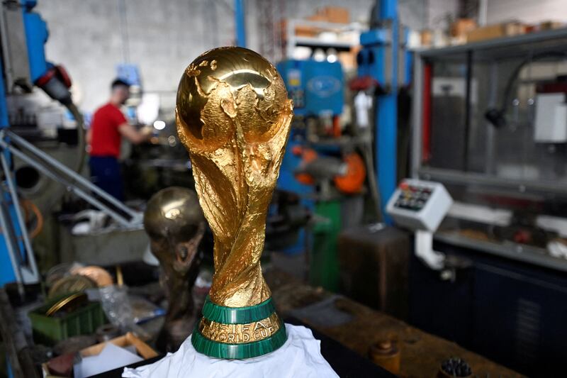 It depicts two stylised athletic figures holding up the globe. Reuters