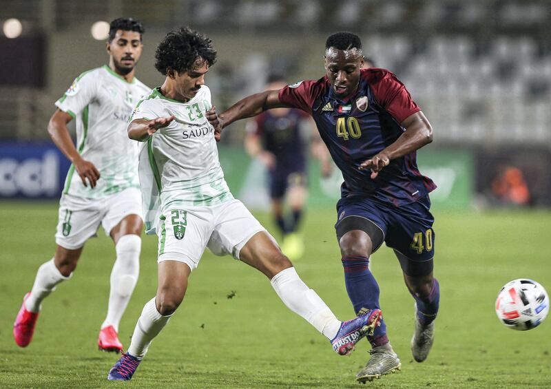 Ahli's defender Abdullah Tarmin (C) vies for the ball against Wahda's midfielder Paul-Jose M'Poku (R) during the AFC Champions League group A football match between al-Wahda FC and al-Ahli FC at al-Nahyan Stadium in Abu Dhabi on February 10, 2020. (Photo by - / AFP)