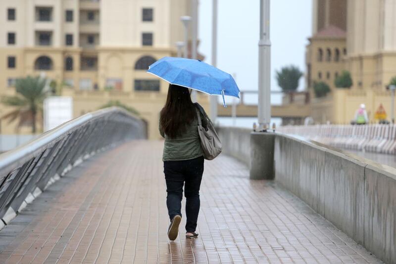 A woman with an umbrella at Dubai Marina. Jaime Puebla / The National