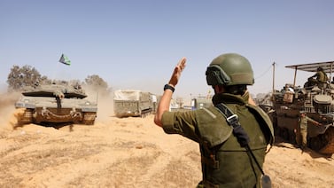 A soldier directs Israeli tanks near a border crossing to the southern Gaza Strip. Bloomberg