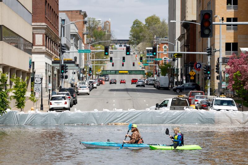 Kayakers paddle along River Drive where sand barriers are protecting Davenport from the rising Mississippi, in Iowa. AP