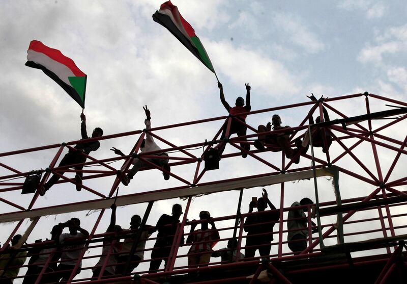 Sudanese civilians wave their national flags during celebrations of the signing of the Sudan's power sharing deal,. REUTERS/Mohamed Nureldin Abdallah