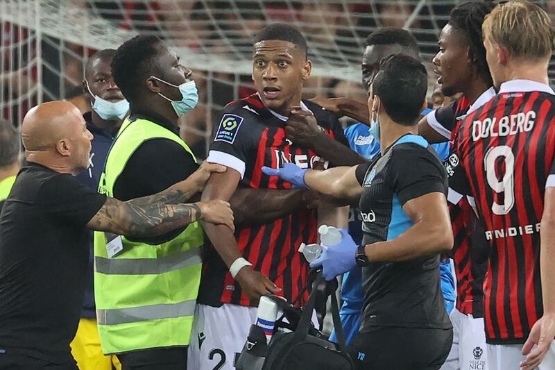 Marseille's Argentine head coach Jorge Sampaoli (R) holds back Nice's French defender Jean-Clair Todibo as fans try to invade the pitch during the French L1 football match between OGC Nice and Olympique de Marseille (OM) at the Allianz Riviera stadium in Nice, southern France on August 22, 2021.  (Photo by Valery HACHE  /  AFP)