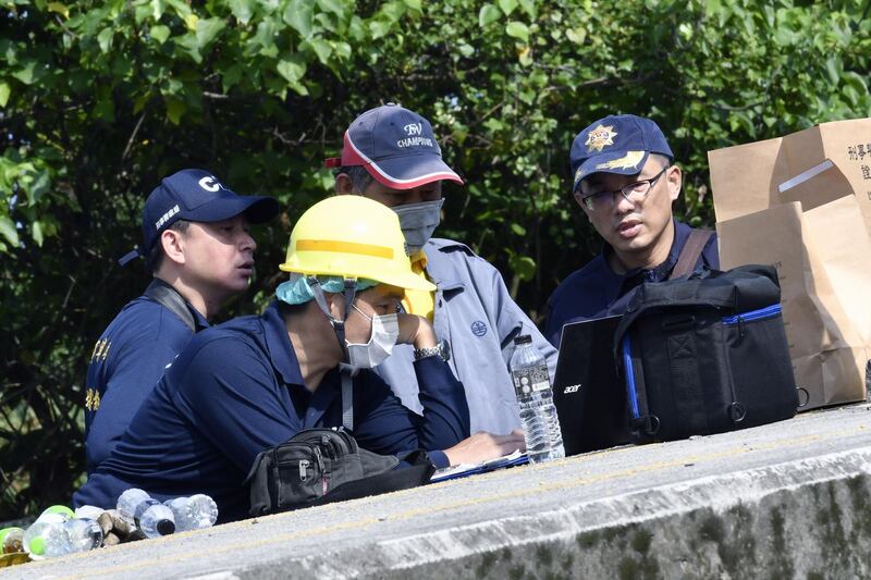 Investigators check a laptop at a platform where a Puyuma Express train derailed in Yilan, eastern Taiwan.  AFP