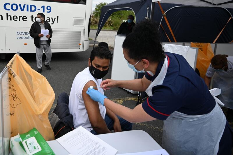 A member of the public receives a Covid-19 vaccine at a temporary vaccination centre at the Essa academy in Bolton, northwest England on May 14, 2021. England remains on track for the latest easing of its coronavirus lockdown next week but is taking no chances after a doubling of cases of an Indian variant, the government said today. / AFP / Oli SCARFF
