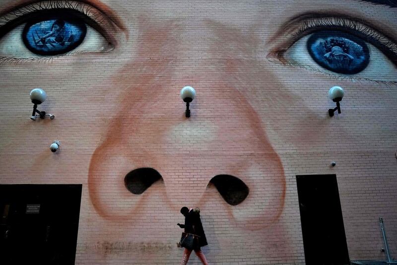 A woman walks past a mural by artist Jorge Rodriguez-Gerada  on the Westin Grand Central Hotel in midtown New York in New York which is now the largest commissioned mural in the city.  The mural has been created for Street Art for Mankind to advocate against child labour and child trafficking. AFP