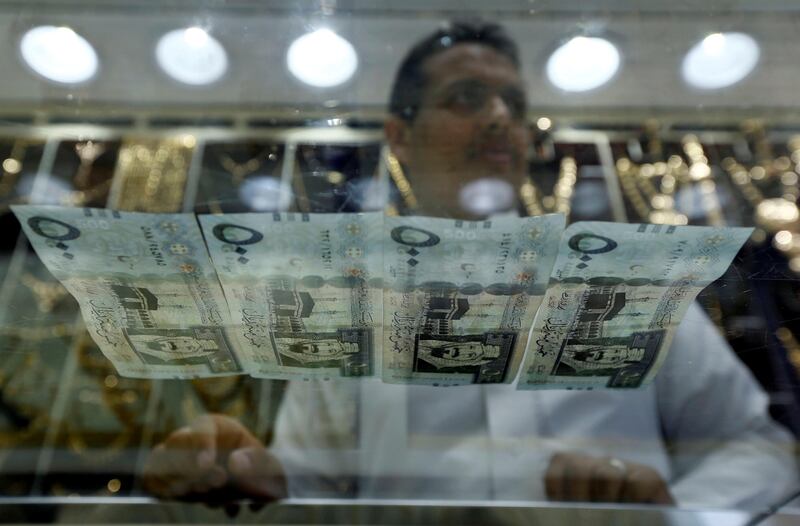 Saudi Riyal banknotes are seen through a glass as a vendor sells jewels in a store in Riyadh, Saudi Arabia, October 18, 2017. Picture taken October 18, 2017. REUTERS/Faisal Al Nasser