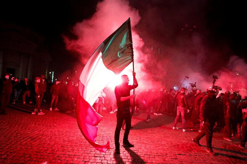 A far right demonstrator holds an Italian flag during a protest over the restrictions put in place to curb Covid-19 infections in Rome, Italy. Reuters