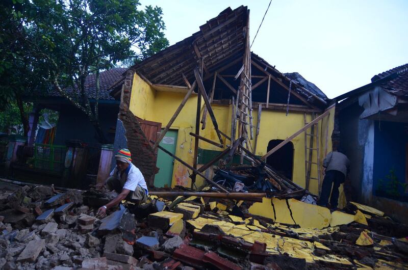 A man cleans up the wreckage of a house damaged by an earthquake in Sumelap Village, Tasikmalaya City, West Java, Indonesia. Antara Foto / Adeng Bustomi / Reuters
