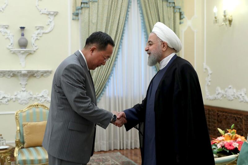 In this photo released by an official website of the office of the Iranian Presidency, President Hassan Rouhani, right, greets North Korean Foreign Minister Ri Yong Ho at the start of their meeting, at the presidency office, in Tehran, Iran, Wednesday, Aug. 8, 2018. (Iranian Presidency Office via AP)