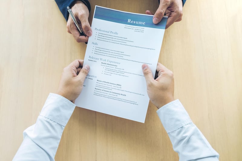 Business man holding his resume during job interview to Executive reading and consider, Hiring concept. Getty Images