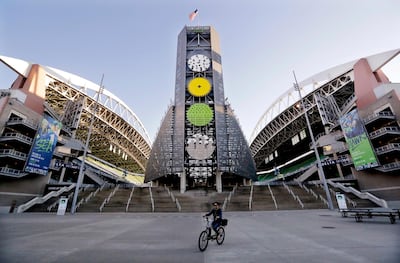 A bicyclist rides past the Seattle Seahawks' stadium Monday, Oct. 15, 2018, in Seattle. Paul Allen, who was an avid sports fan and owned the Seahawks and the Portland Trail Blazers, has died. He was 65. Allen's company Vulcan Inc. said in a statement that he died Monday. Earlier this month Allen said the cancer he was treated for in 2009, non-Hodgkin's lymphoma, had returned. (AP Photo/Elaine Thompson)