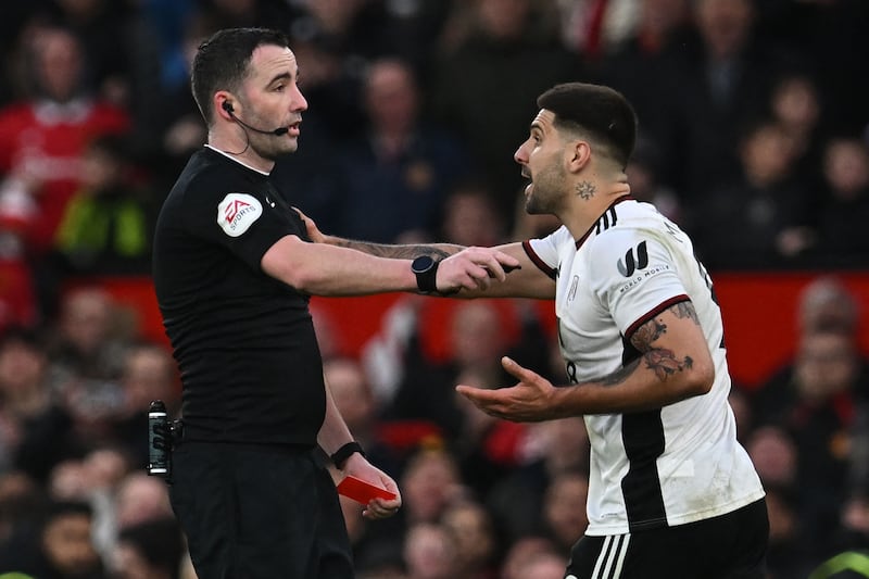 Fulham's Serbian striker Aleksandar Mitrovic (R) argues with English referee Chris Kavanagh (L) and gets himself sent off during the English FA Cup quarter-final football match between Manchester United and Fulham at Old Trafford in Manchester, north-west England, on March 19, 2023.  (Photo by Paul ELLIS / AFP) / RESTRICTED TO EDITORIAL USE.  No use with unauthorized audio, video, data, fixture lists, club/league logos or 'live' services.  Online in-match use limited to 120 images.  An additional 40 images may be used in extra time.  No video emulation.  Social media in-match use limited to 120 images.  An additional 40 images may be used in extra time.  No use in betting publications, games or single club/league/player publications.   /  
