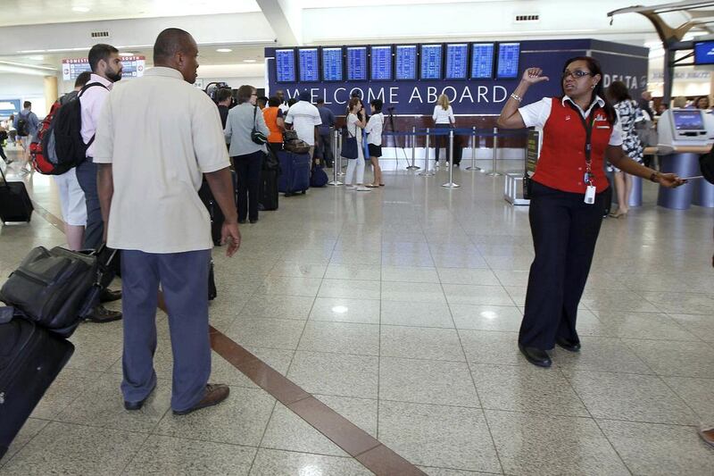 A Delta Air Lines employee (right) gives directions to passengers arriving as they wait in the ticketing area after Delta Air Lines’ computer systems crashed on Monday, grounding flights around the globe, at Hartsfield Jackson Atlanta International Airport in Atlanta, Georgia, US. Tami Chappell / Reuters