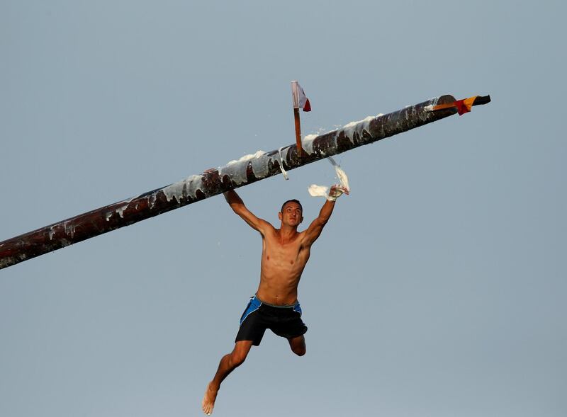 A competitor tries to grip a pole covered in lard before he falls into the sea during the celebrations of the religious feast of St Julian, Malta. Darrin Zammit Lupi / Reuters