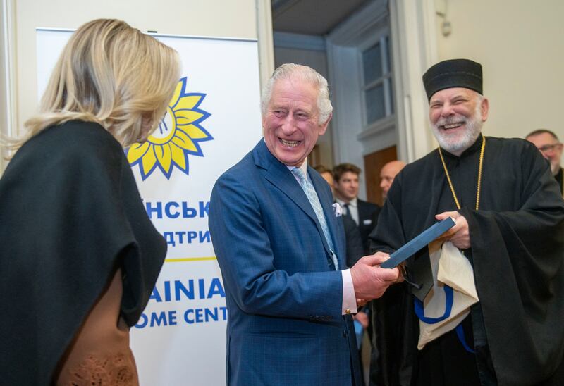 Britain's King Charles III laughs during a visit to a new welcome centre for Ukrainians in London. AP