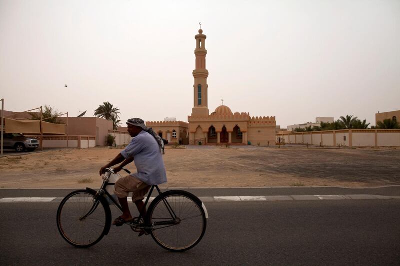 Madinat Zayed, United Arab Emirates, May 8, 2013:    A man rides a bicycle past a mosque in Madinat Zayed the day an announcement was made by the Executive Council that the road to Al Ghayathi would be enlarged from two lanes to four on May 8, 2013. Christopher Pike / The National