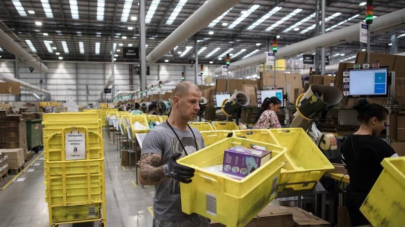 Employees pack boxes of merchandise at an Amazon.com  fulfillment center in Peterborough, UK. Amazon has forecast a potential quarterly loss for the first time in two years. Simon Dawson/Bloomberg