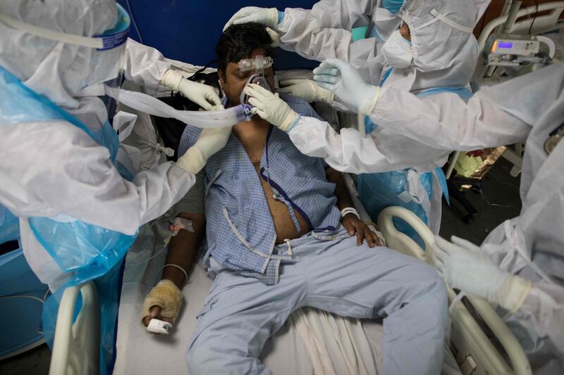 Doctors and nurses wearing personal protective equipment look after a coronavirus patient at the intensive care unit of the Sharda Hospital, in Greater Noida, in northern India. AFP