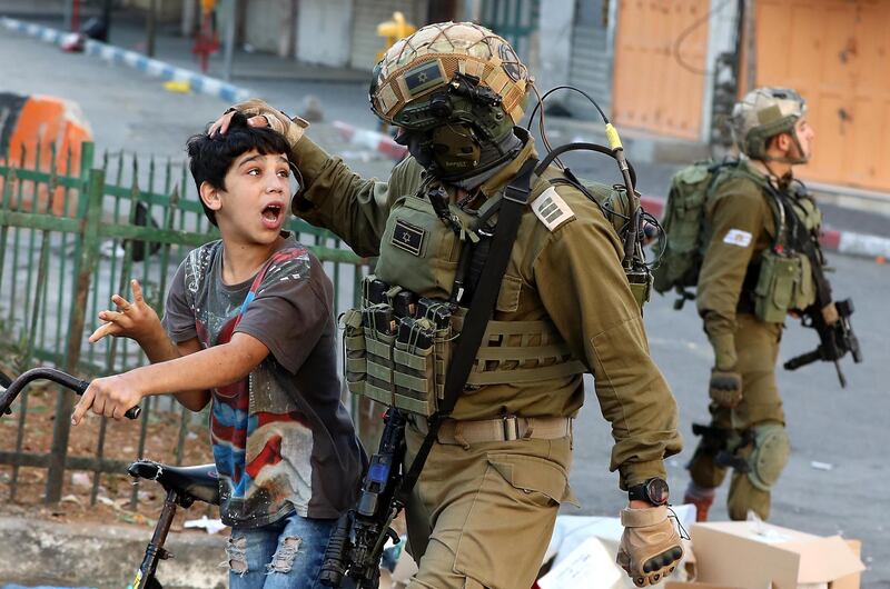 Israeli soldiers arrest a Palestinian boy, as he is accused of throwing stones during clashes in the west bank city of Hebron.  EPA