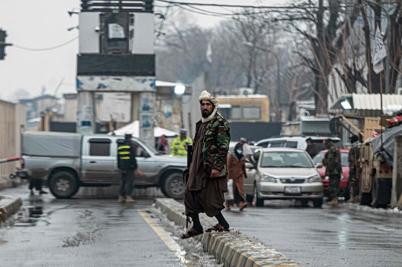 Taliban fighters stand guard at the scene of the bomb blast. AFP
