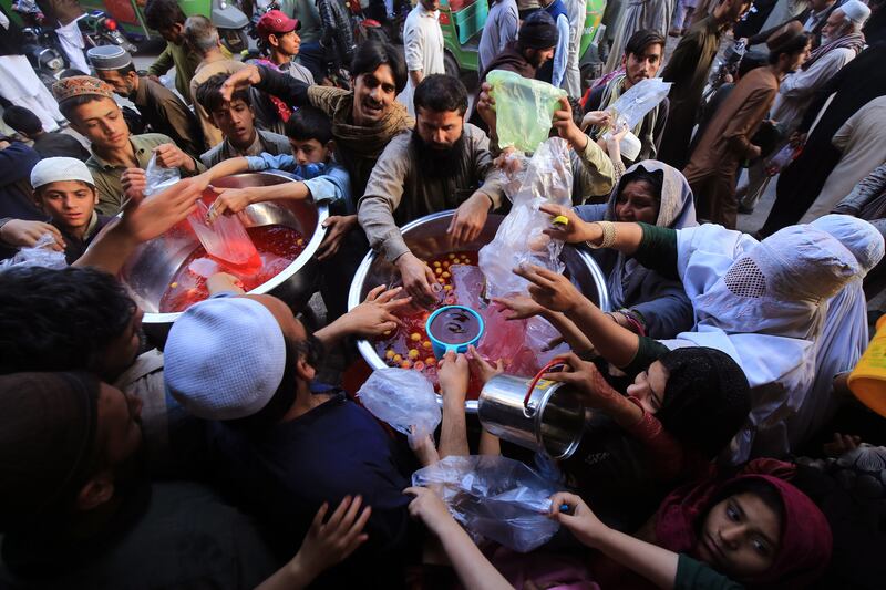People receive free sweet drinks for iftar in Peshawar, Pakistan. EPA