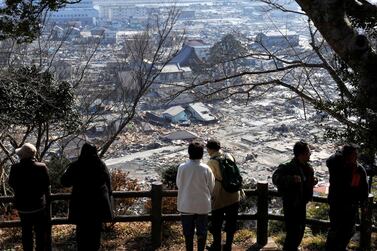 Survivors of the tsunami that devasted the Fukushima nuclear plant  look over the remains of Ishinomaki in Miyagi Prefecture, about 270km north of Tokyo. Japan is facing a choice over the future of its energy policy. Kimimasa Mayama / EPA