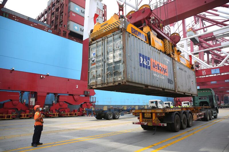 A worker wearing a face mask to protect against the new coronavirus guides the loading of a shipping container at a container port in Qingdao in eastern China's Shandong Province, Thursday, July 9, 2020. Chinaâ€™s imports of U.S. goods rose 10.6% in June over a year earlier and its global trade also increased in a fresh sign the worldâ€™s second-largest economy is gradually recovering from the coronavirus pandemic, customs data showed Tuesday July 14, 2020. (Chinatopix via AP)
