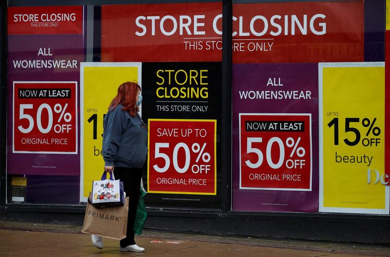 A woman walks past sale signs in the windows of a Debenhams store at the start of the Boxing Day sales in Manchester. Reuters