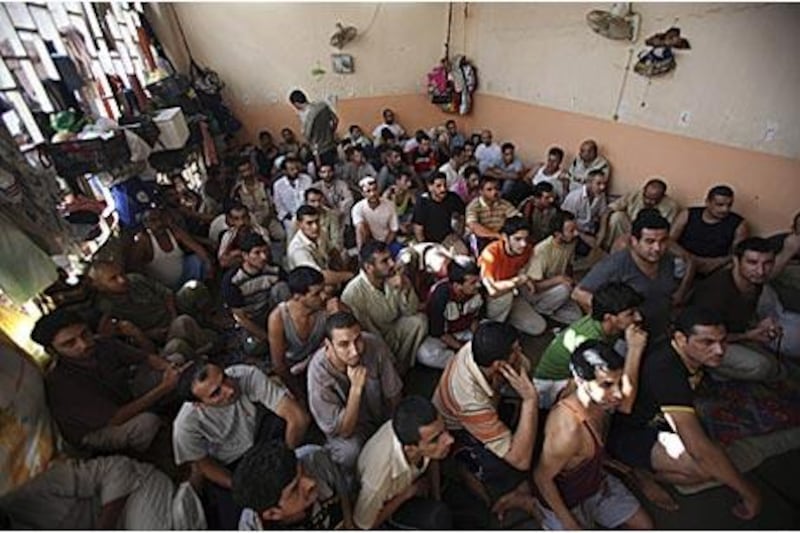 Men sit in a crowded cell in a jail in Baghdad, where human rights groups say inmates are kept in appalling conditions and routinely tortured.