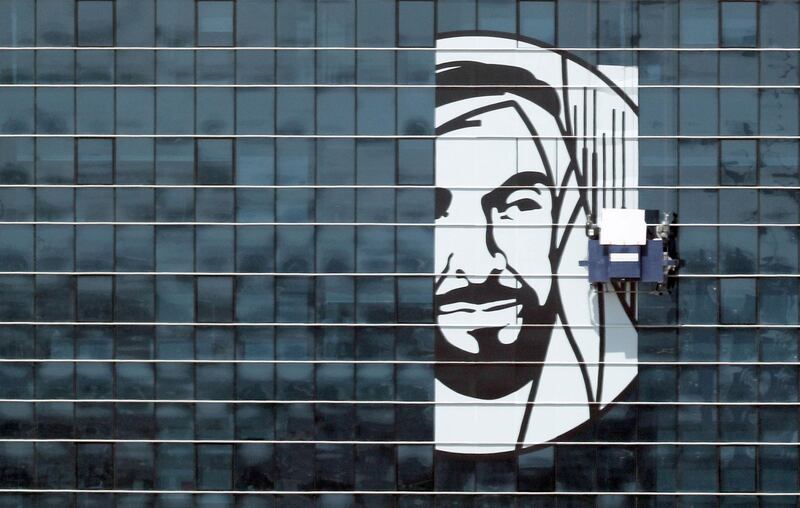 Abu Dhabi - 25th Mar 2018 - Workers sticking a poster of Father of Nation Late Sheikh Zayed bin Sultan Al Nahyan poster on the FAB headquarter building near Khalifa park to mark the Year of Zayed around UAE. Ravindranath K / The National 