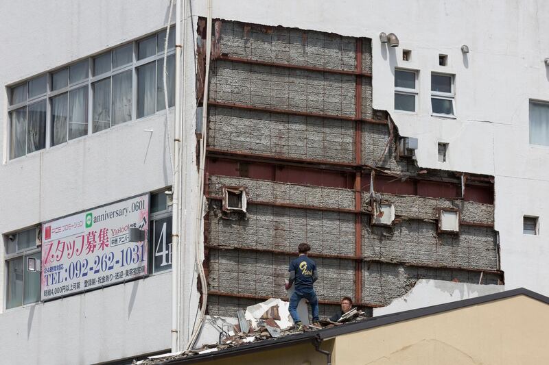 People work to clean a collapsed wall of a building in Fukuoka, Japan. Getty Images